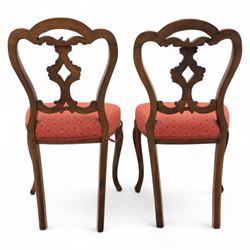 Set of four Victorian walnut balloon back chairs, with a carved and pierced back splat with foliate scrolls, serpentine seat upholstered in a diamond pattern fabric, raised on cabriole legs 