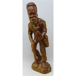  African style carved hard wood figure of a barefoot man holding a pineapple and a hoe, H63cm  