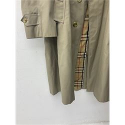 Ladies Burberry double breasted trench coat, with belt and detachable woollen gilet, in traditional cream colour with Burberry check lining, together with a gentlemans Burberry single breasted trench coat, both L112cm