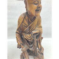 Pair of Japanese carved wooden figures, modelled as merchants in traditional dress, upon pierced naturalistic bases, tallest H39cm