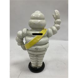 Cast iron money bank of a waving Michelin man stood on a tyre, H23cm