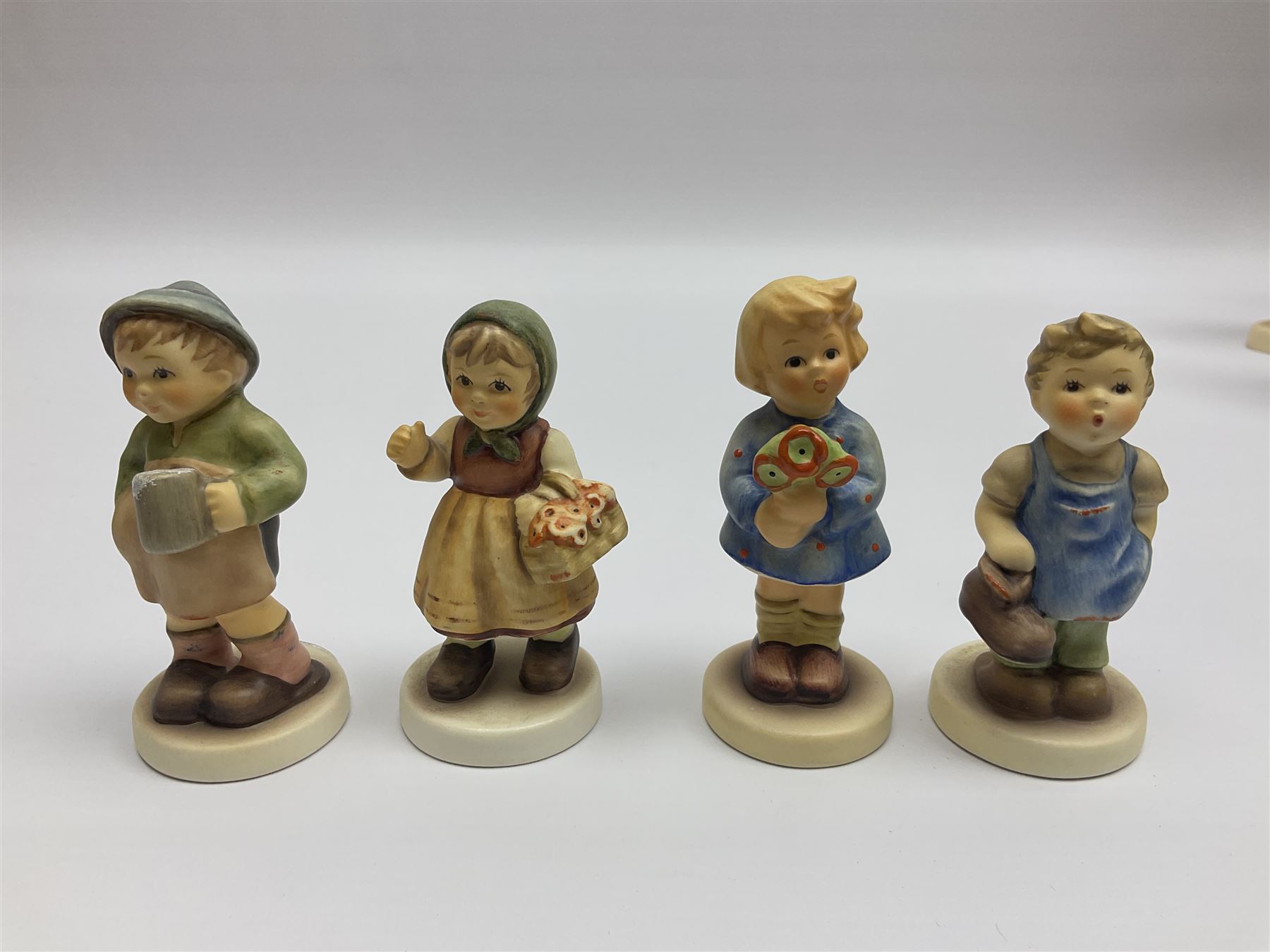 Thirty Hummel figures by Goebel, to include Saluting the Peacekeepers of Operation Joint Endeavor, on wooden plinth, Call to Glory, Celebrate with Song and Soldier Boy