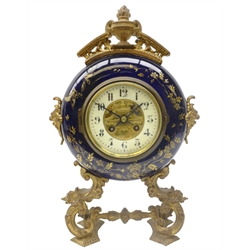  19th century French gilt metal mounted ceramic circular mantel clock, cream Arabic dial with urn centre and cresting, twin train Japy & Co movement stamped 66256 striking the half hours on a bell, on C scroll supports joined by a stretcher, H38cm  