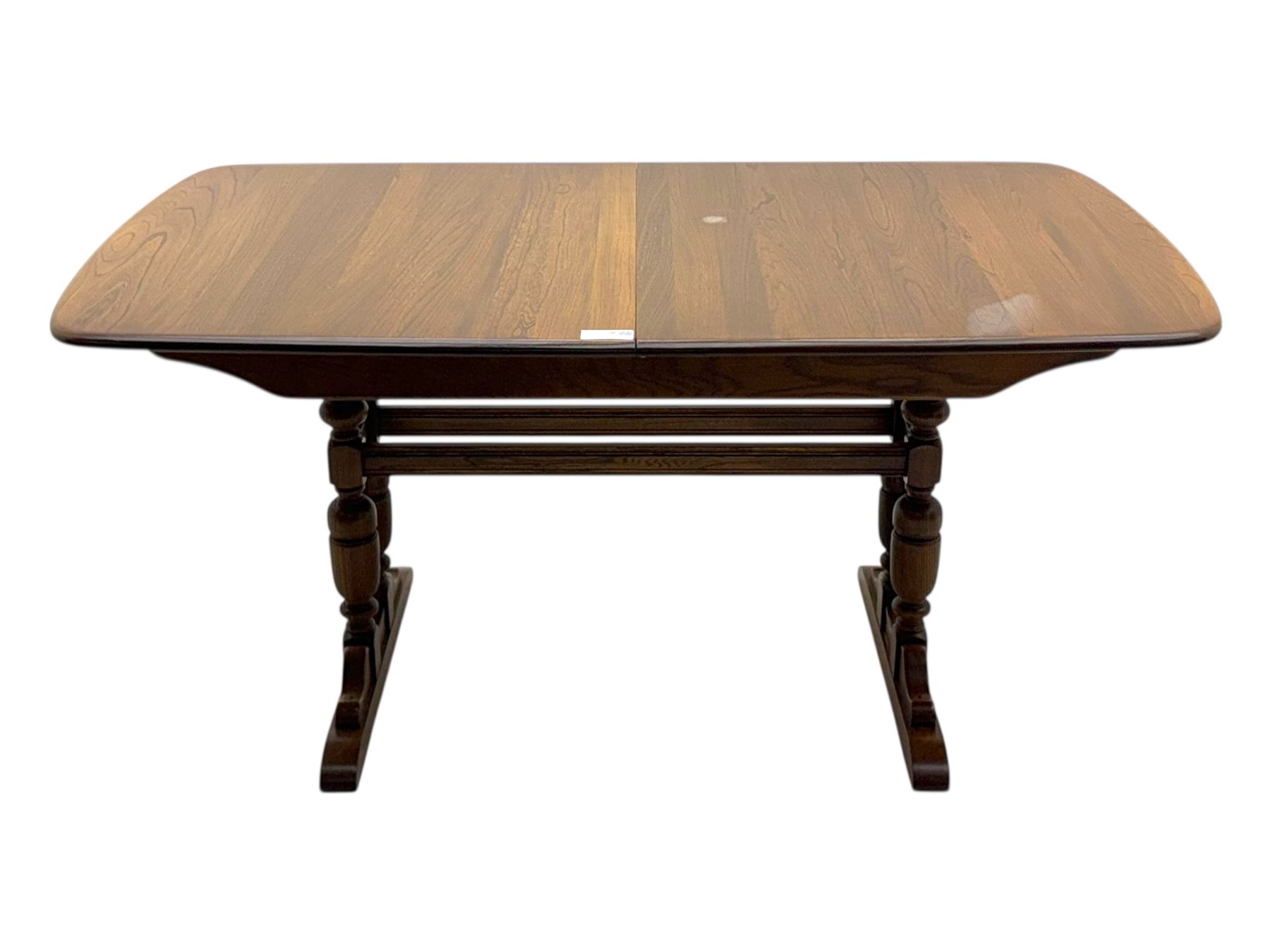 Ercol - late 20th century oak refectory dining table, rectangular top with rounded corners and central extending leaf, raised on turned baluster supports united by a stretcher (Extended 200cm)