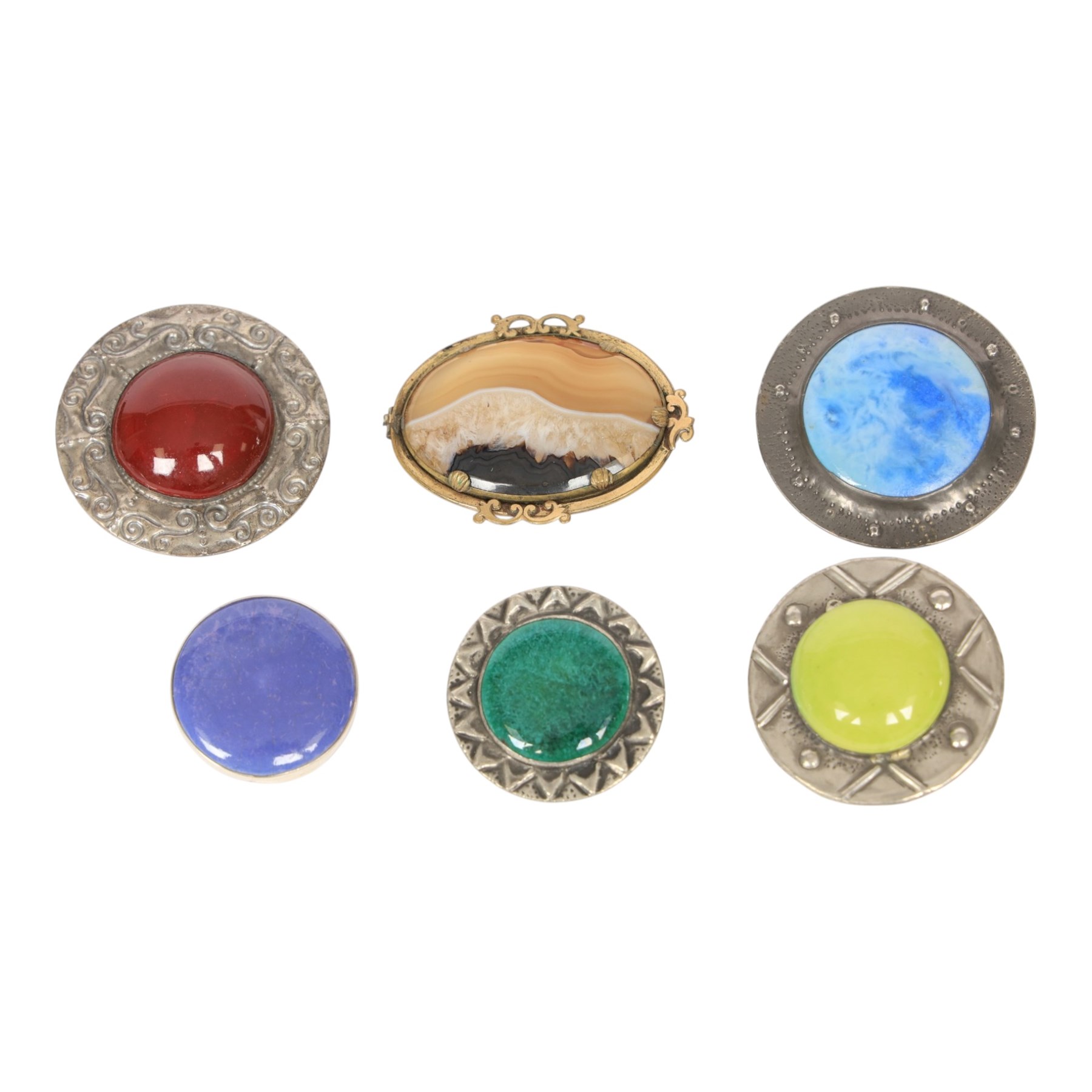 Six brooches, including one Ruskin example in silver mount, four Ruskin style brooches with ceramic roundels and a plated agate example