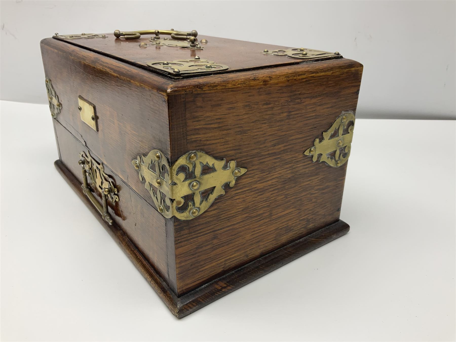 Brass mounted oak humidor, the slide action top opening to a base drawer, cedar lined with central compartment and striker, the drawer stamped Rd 107198, H17cm, D18cm