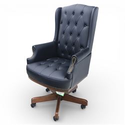 Chesterfield style desk chair upholstered in black, brass studded trim with tall button backed seat, with faux wooden base raised upon castors