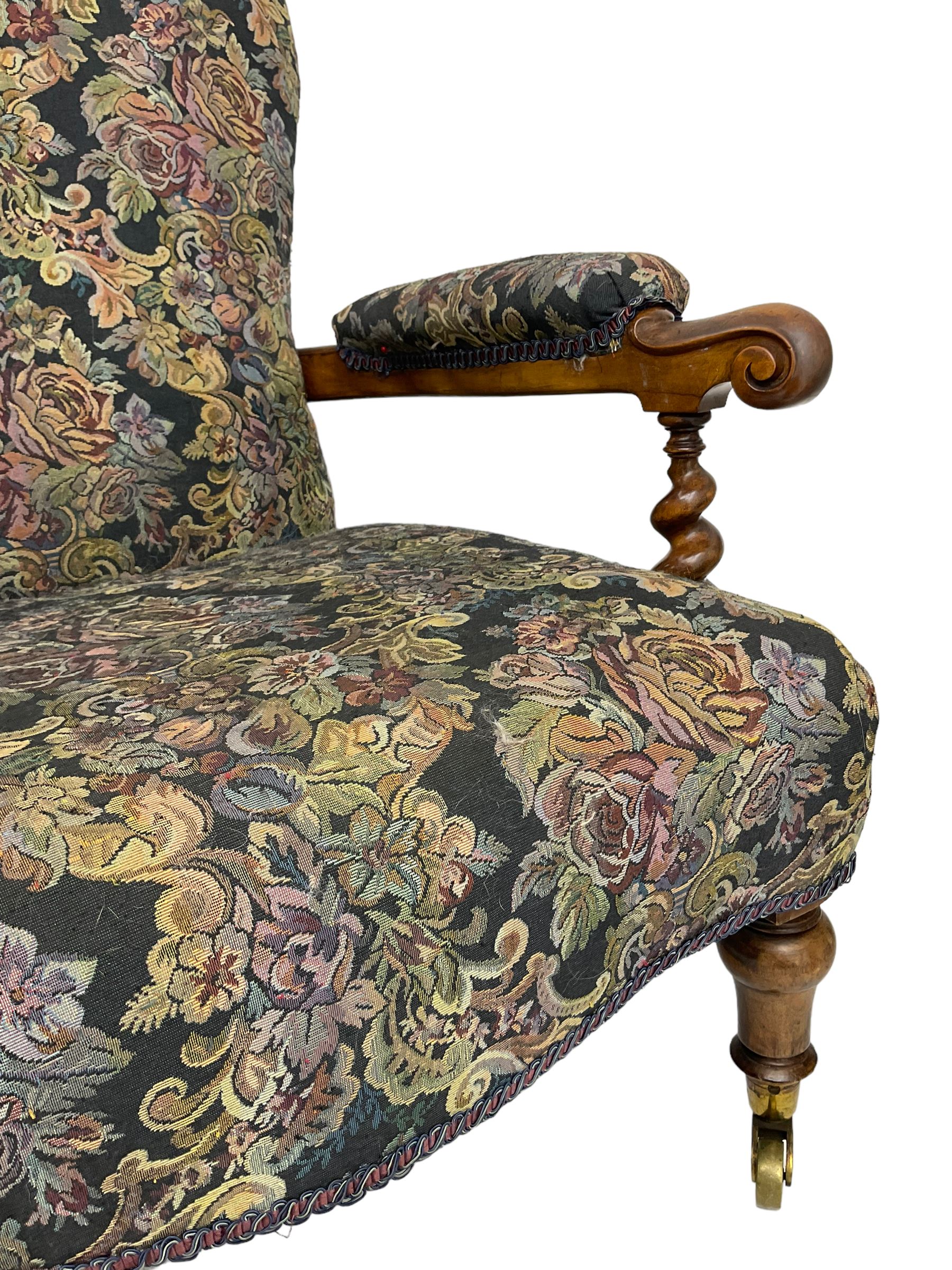 Victorian walnut framed open armchair, scrolled arm terminals over spiral turned arm supports, upholstered in foliate patterned fabric with sprung seat, on turned supports and brass castors (W65cm H92cm); and Victorian mahogany nursing chair with lobe carved supports (W60cm H92cm)
