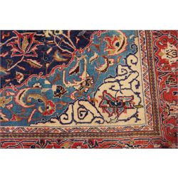 North West Persian Sarouk hand-knotted rug, indigo field with central stepped medallion with pendants, issuing an all-over arrangement of scrolling vinery, palmettes and stylized floral sprays, enclosed by a broad turquoise field of sinuous arabesques,, ivory spandrels with foliate decoration, madder red main border of stylized palmettes, and flowering vines, flanked by reciprocal guard stripes, cotton fringe ends 