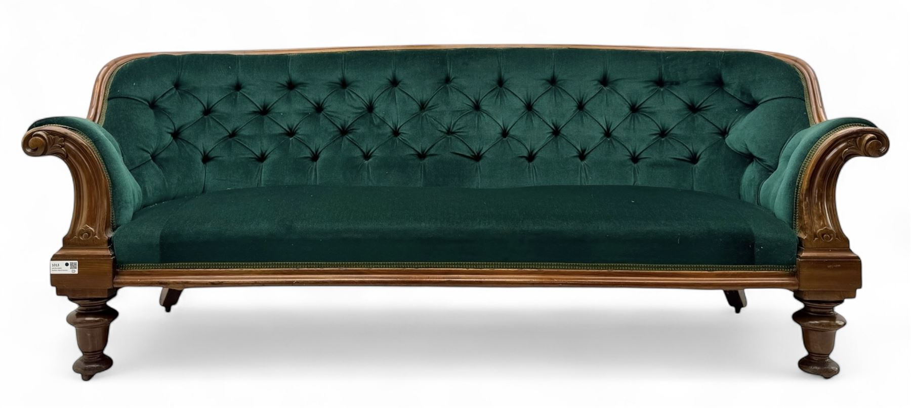 Victorian mahogany settee, upholstered in green buttoned fabric, moulded frame and scroll carved arm terminals, turned supports on castors