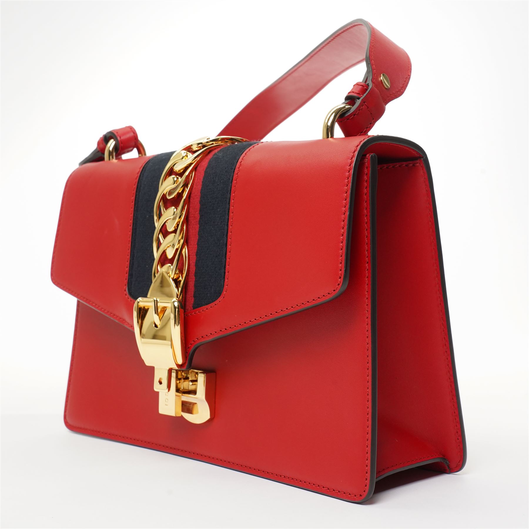 Gucci - ‘Sylvie’ Small Shoulder Bag, introduced circa 2016 under Alessandro Michele, in red calfskin leather with signature web stripe, gold-tone chain and buckle fastening and hardware, flat leather shoulder strap with alternative web-stripe grosgrain strap, unused with original dust bag