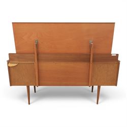 Austinsuite - mid 20th century teak headboard with bedside cabinets and matching  mirrored dressing table, the headboard with floating single drawer bedsides raised on a single tapering support, the dressing table with attached tilting mirror, above rectangular top with kneehole and two banks of two drawers, raised on tapering supports

Headboard H 84cm, D 40cm, W 229cm, W between bedsides 151cm 
Dressing table H 113cm D 44cm, W 149cm, H to underside of dresser 61cm