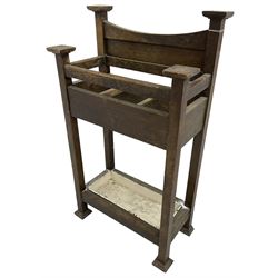Early 20th century Arts & Crafts oak stick stand, panelled back over three divisions, fitted with metal drip tray, on square supports