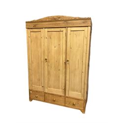 Early 20th century Continental pine triple wardrobe, arched cornice over three panelled doors and drawers
