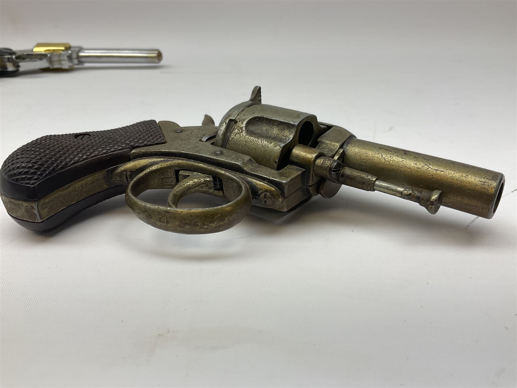 Early 20th century Flobert 5mm blank firing revolver with six-shot chamber, top venting, nickel plated with folding trigger No.118 L12.5cm overall; replica non-firing 'British Bulldog' revolver; and Windproof gas lighter inscribed 'Revolver-99 Spring and Autumn' in holster marked 'Star-Line'