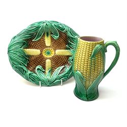 A Victorian majolica bread plate depicting corn within a woven basket, L33cm, together with a Victorian majolica jug modelled in the form of a corn cob, with registration mark beneath, H22cm. 