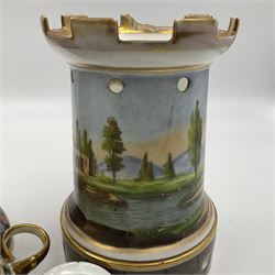 Two 19th century continental teapots and warmers, each teapot upon a cylindrical warming base in the form of a castle, hand printed with landscapes and figures in a religious pose, largest H22cm 