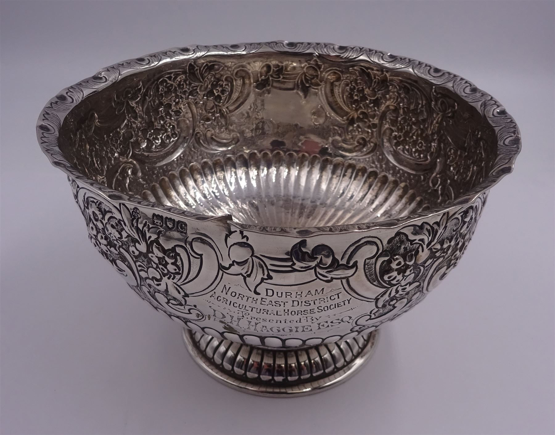 Late Victorian silver rose bowl, of circular form with embossed foliate and C scroll decoration, and engraved personal dedication, upon a part fluted spreading circular foot, hallmarked Wakely & Wheeler, London 1898, H11.5cm D18cm, approximate weight 11.67 ozt (363.2 grams)