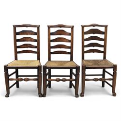 Set of seven (6+1) Georgian design country elm Lancashire dining chairs, ladder backs with rush seats, turned front leg stretcher on pad feet, height of seat 44cm, complete with fitted tie on cushions