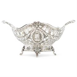 Late 19th/early 20th century German Hanau silver basket, modelled in George II style, of shaped openwork lattice form with twin handles, the body decorated with two portrait roundels and husk and ribbon swags, upon four scroll feet, with unattributed pseudo Hanau marks, and hallmarked John George Piddington, London import 1901, including handles H7cm W15cm
