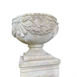Pair of quality Neoclassical design Haddonstone cast stone garden urns, the globular  body decorated with relief foliate festoons and fruiting motifs, over a fluted socle, the rectangular pedestals with relief foliate wreaths and ribbon garlands