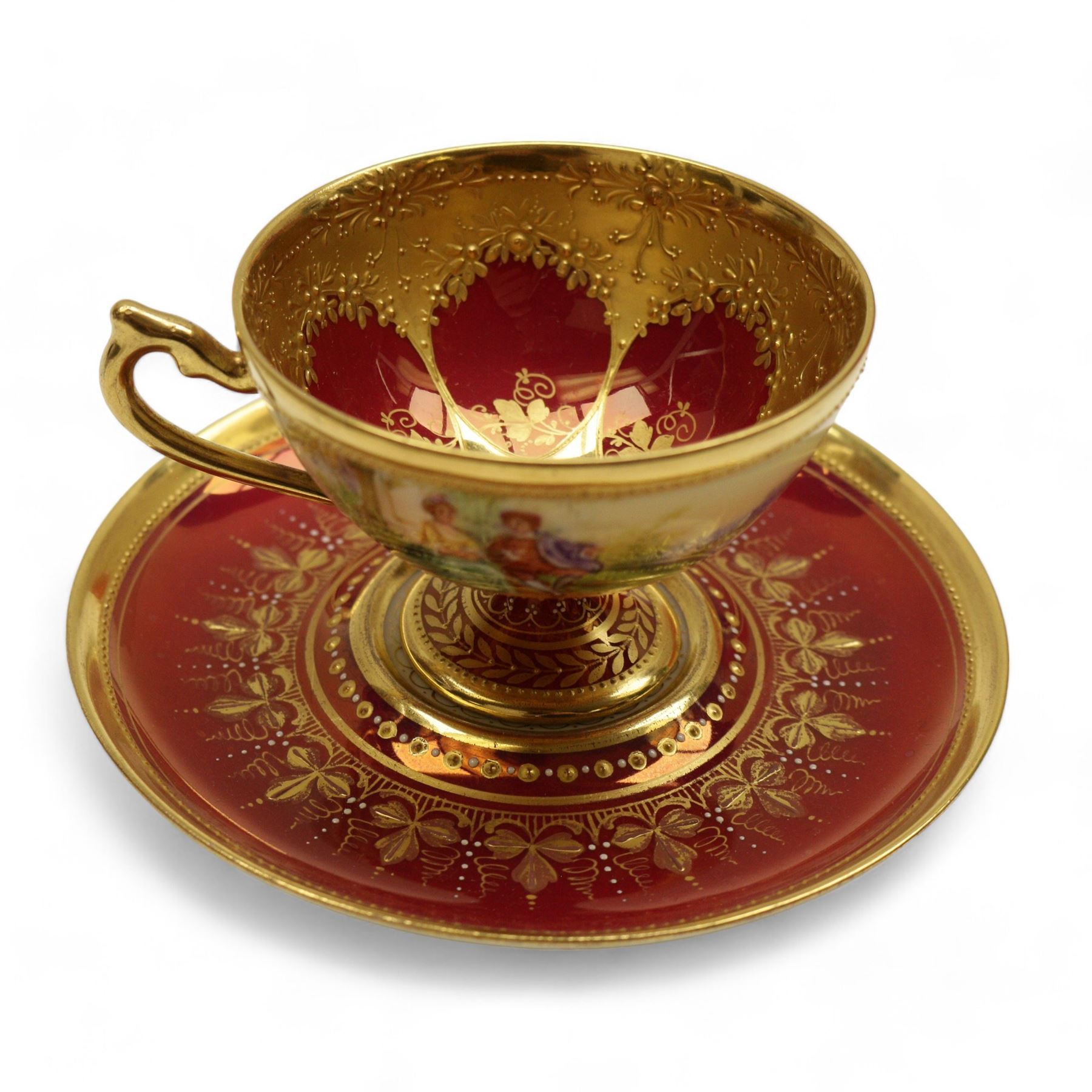 Four early 19th century Dresden cups and saucers, comprising twin handled chocolate cup and cover, decorated with floral swags, cup and saucer decorated with children dancing and two others 