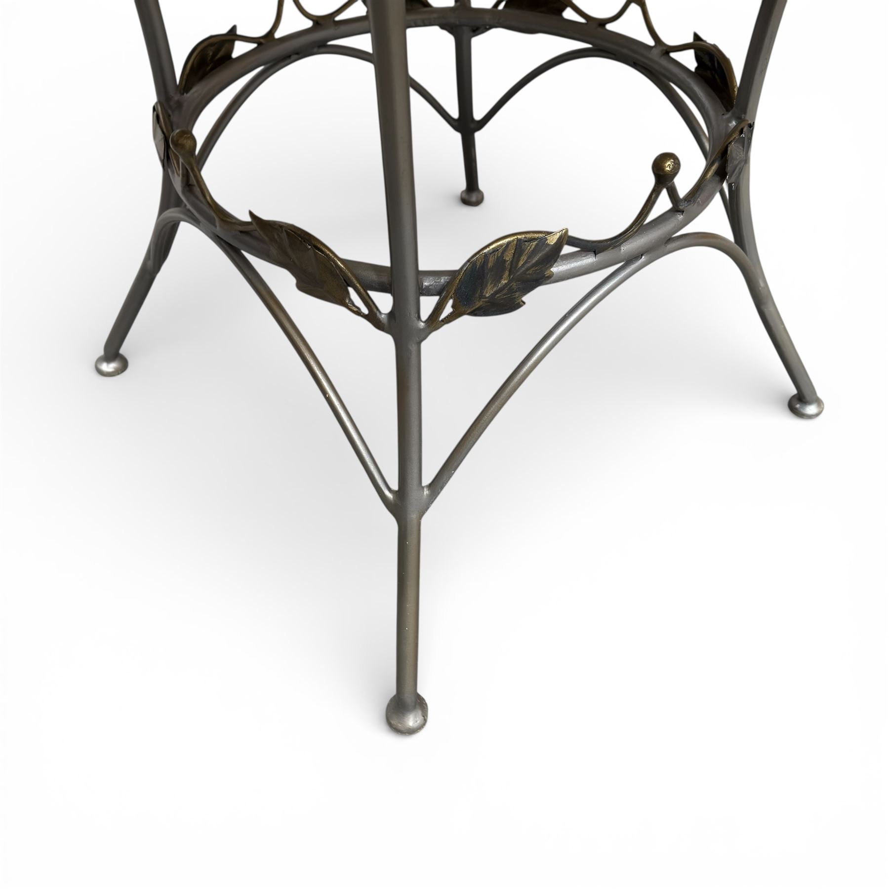 Wrought iron garden dining table with leaf decoration, and set of four matching chairs
