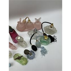 Art Deco style glass perfume bottles and atomisers, to include a large amber example with stopper of fan shape, H18cm, green glass examples with metal stoppers, and a number of other Art Deco style coloured bottles of geometric form with stoppers and mounts