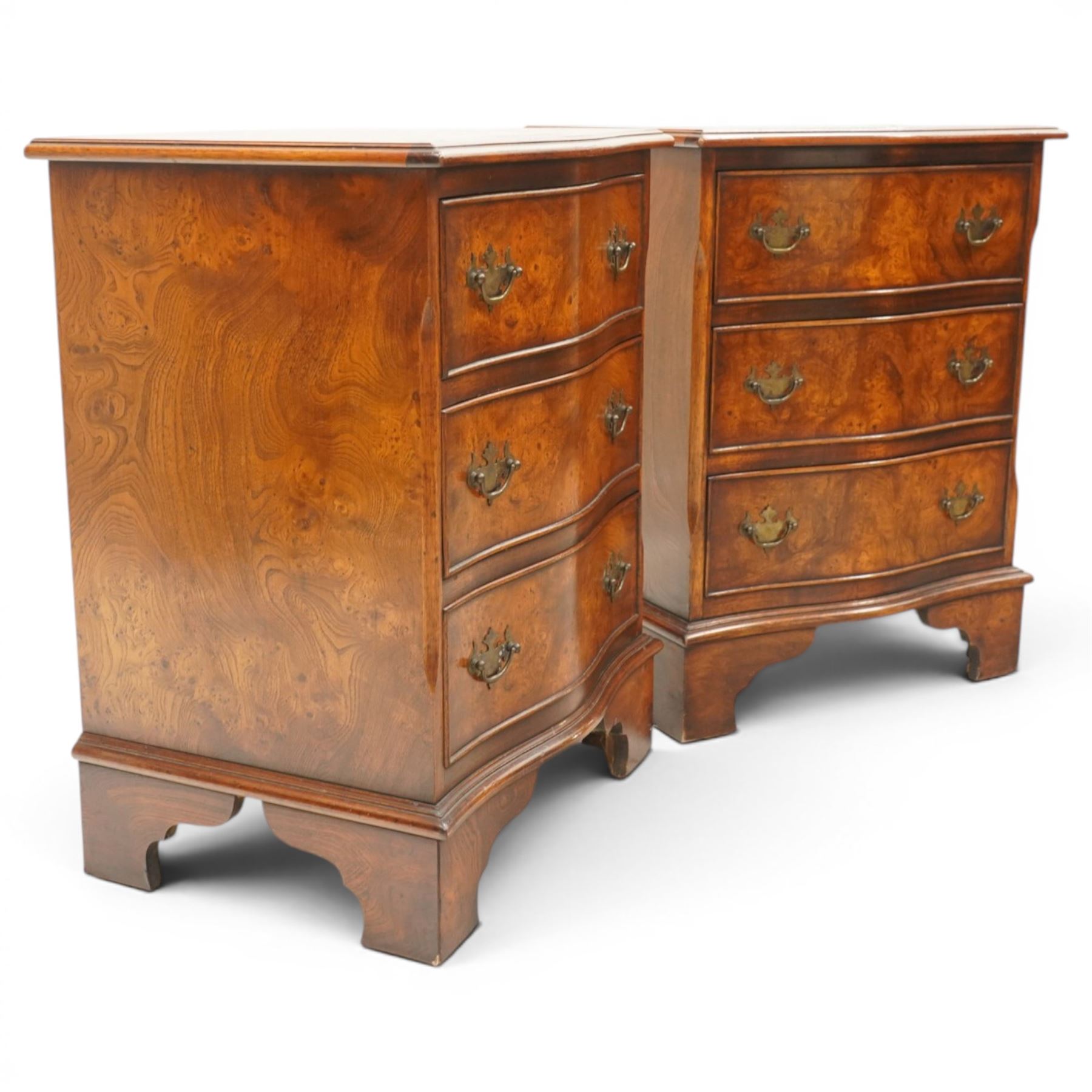 Pair of Georgian design figured elm serpentine bedside chests, moulded top raised on bracket feet