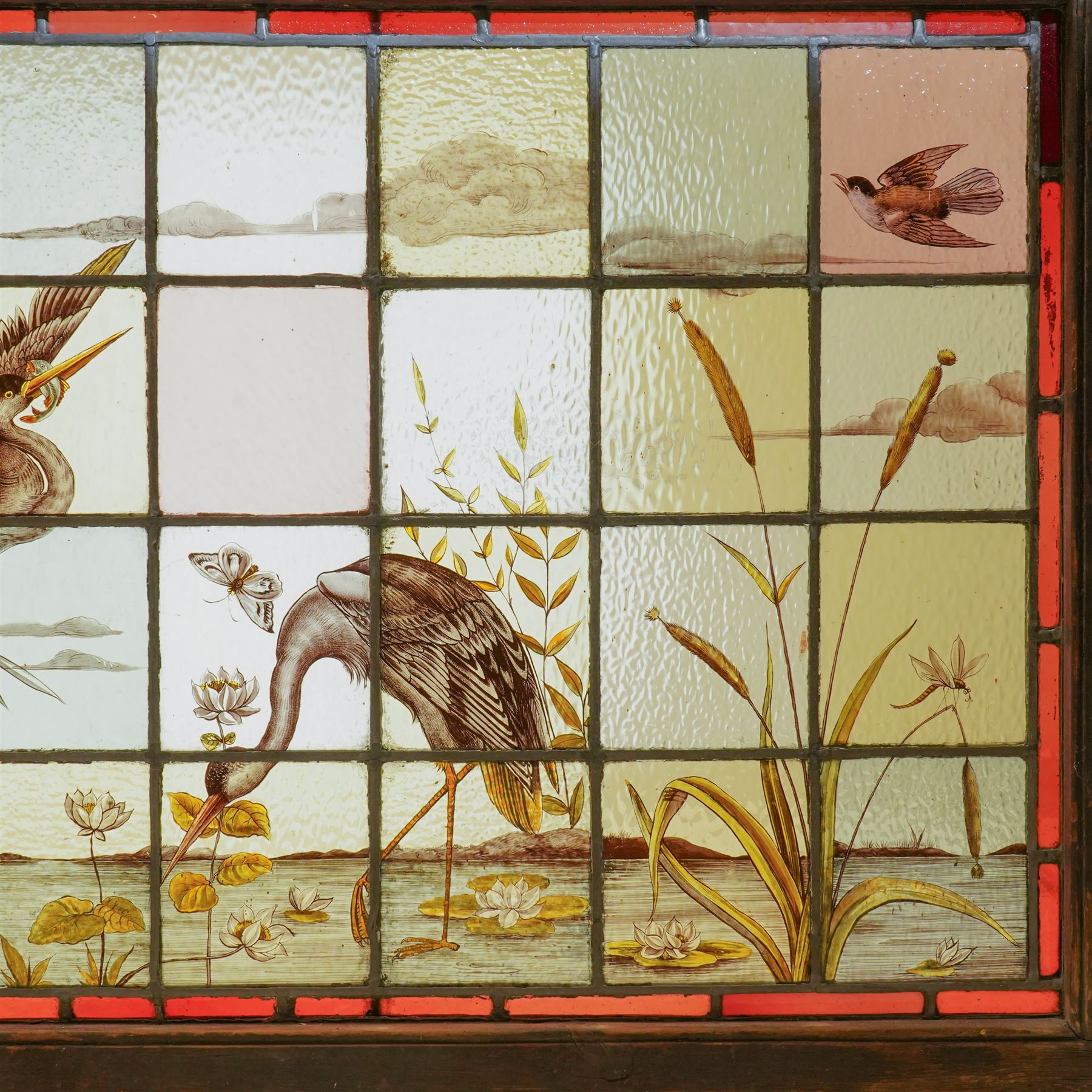 Large Victorian Aesthetic movement stained glass leadlight window panel, hand painted with a scene of herons and other birds in a lake, overall 82cm x 147cm 