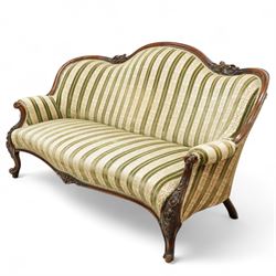 Victorian walnut framed salon sofa, the shaped back and scroll arms with carved floral detail, upholstered in green and cream striped fabric, raised on scrolled cabriole legs 