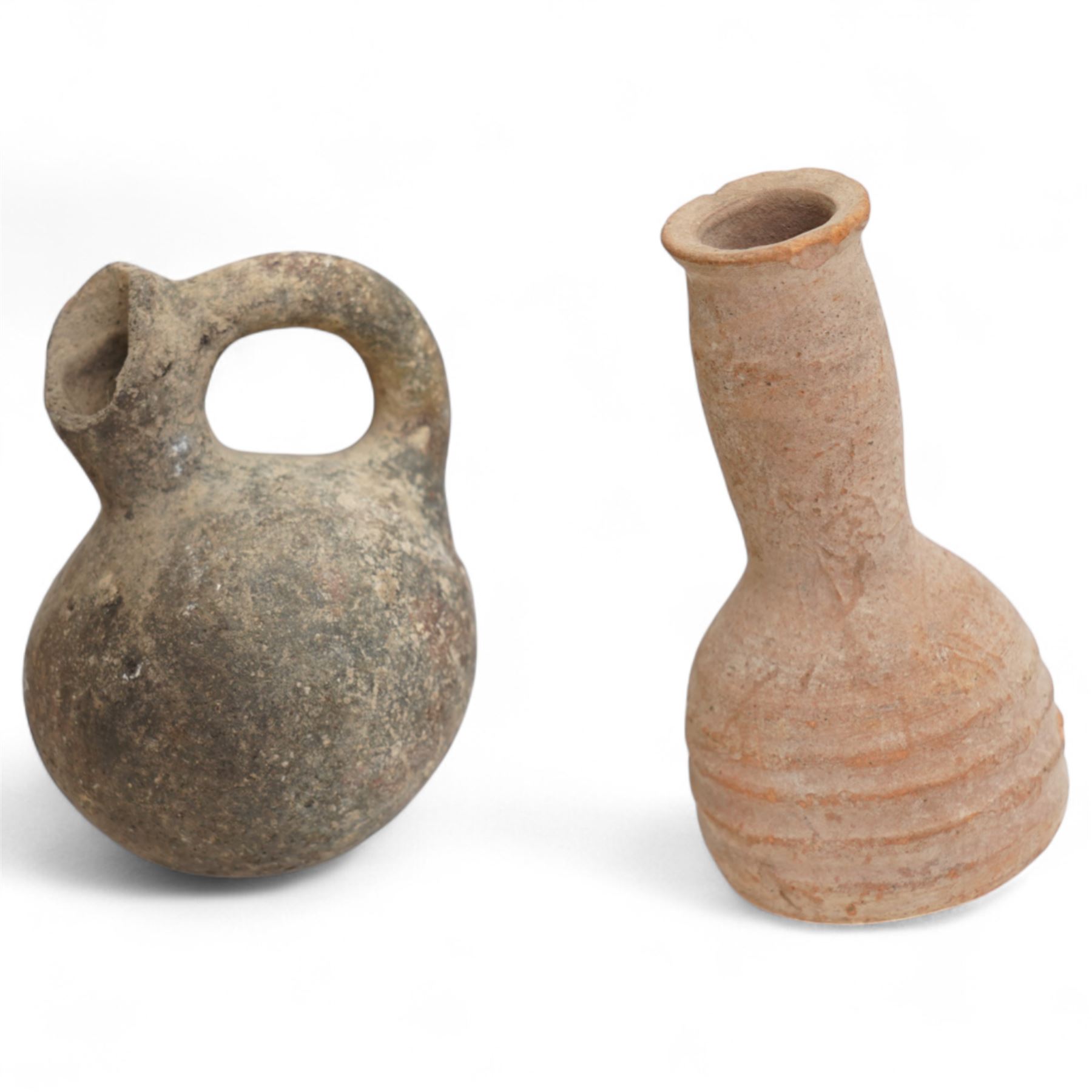 A group of eight ancient terracotta vessels - Near East and Eastern Mediterranean c.2nd millennium BC-1st century AD, comprising a Nabataean red terracotta ‘eggshell’ bowl (c.1st century BC-1st century AD) finely wheel-made with a thin-walled hemispherical form and pale red slip; a Near Eastern black-burnished spouted vessel (c.1800-1600 BC) of globular form with single handle and short spout; large Roman or Late Iron Age single-handled jug (c.1st century BC-1st century AD) wheel-made with a wide neck and ovoid body; together with five further vessels including shallow dishes, squat jars and a ribbed bottle, likely of Middle Bronze Age Levantine and Roman provincial types.
Provenance: By the vendor’s repute, acquired/collected in the Middle East (Dead Sea area/Syria) in the 1960s