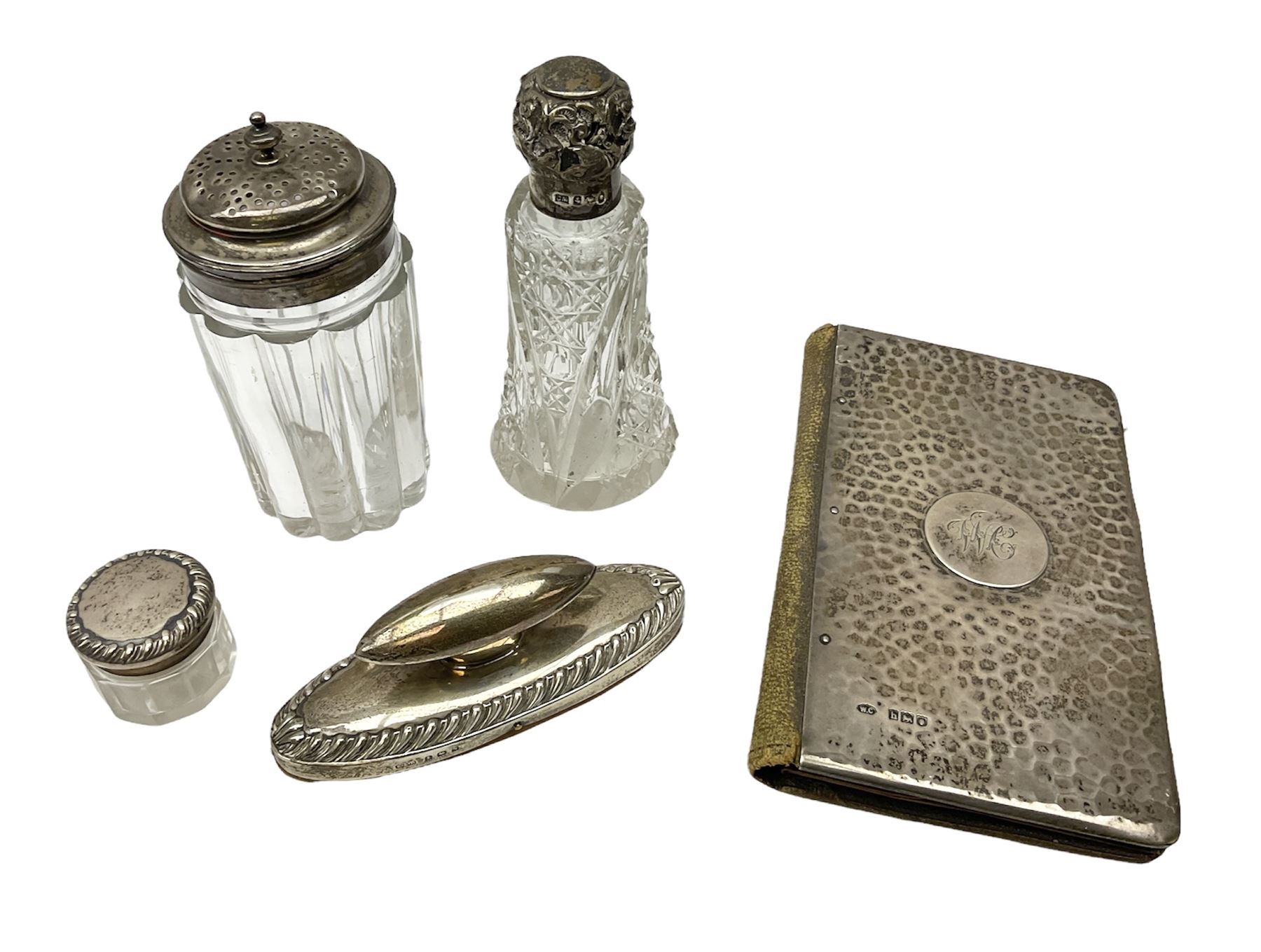 Edwardian silver mounted purse, with circular panel engraved with initials, and hammered finish, hallmarked William Comyns & Sons, London 1903, H14cm, together with three dressing table glass jars with hallmarked silver covers, and a hallmarked silver mounted buffer 