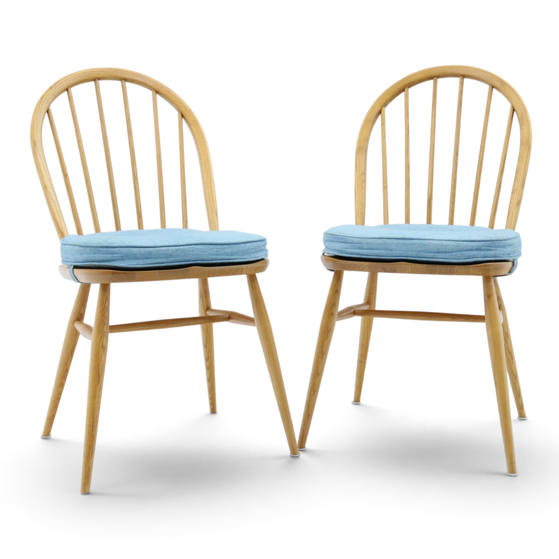 Ercol - pair of 'Windsor' dining chairs, with high hooped back, blue seat cushions with studded, tapered supports  