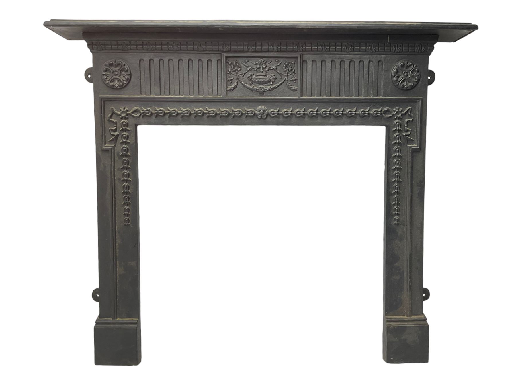 Adam design - cast iron fire surround, moulded rectangular mantel over central foliate urn and vertical flutes, flanked by C-scroll floral roundels, the aperture decorated with trailing bellflowers