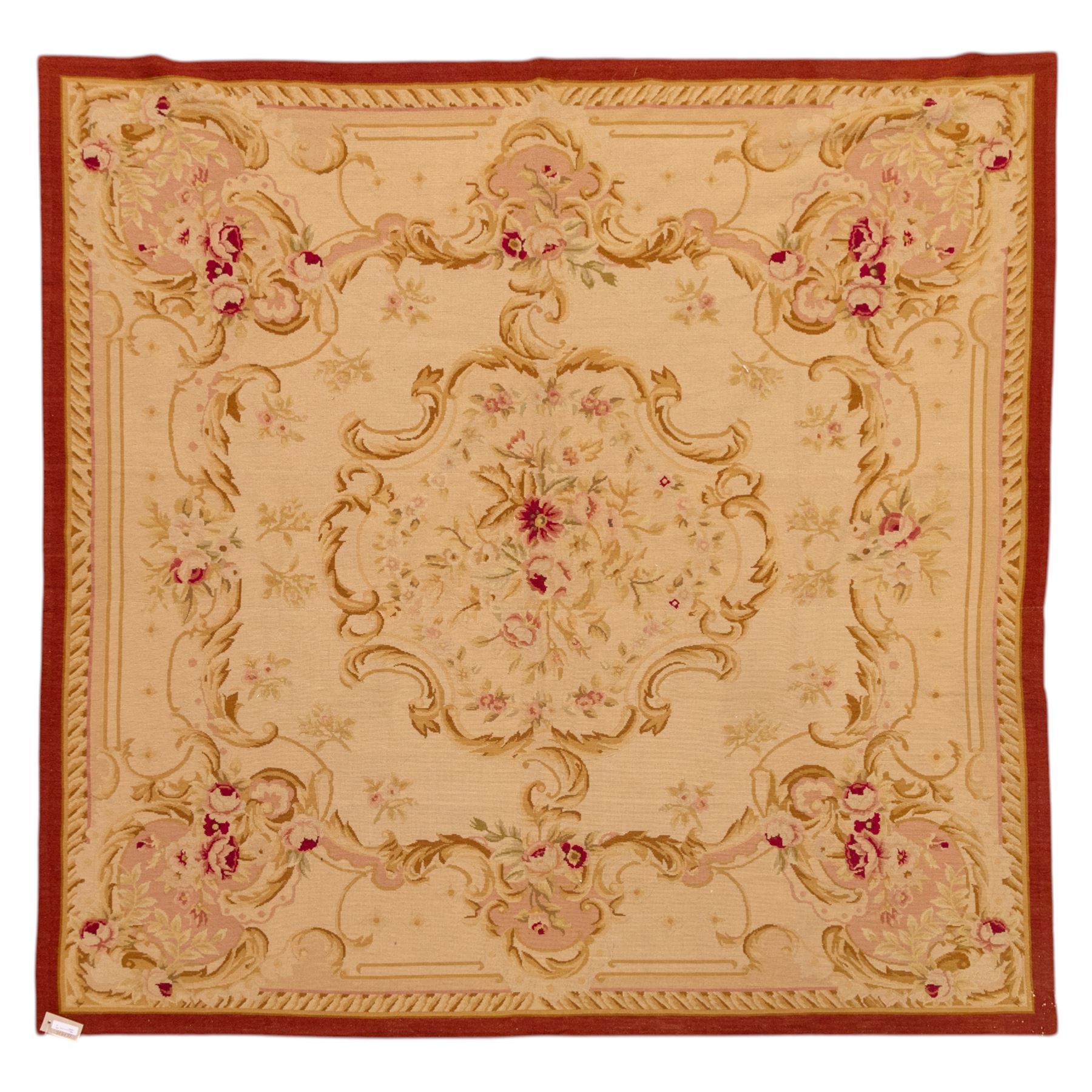 20th-century Aubusson-style tapestry wall hanging of square form, woven with a central floral medallion composed of delicate sprays in soft pinks, creams, and muted greens, framed by scrolling acanthus ornamentation and floral cartouches to each corner, all set within a pale ivory ground and enclosed by a terracotta toned border 