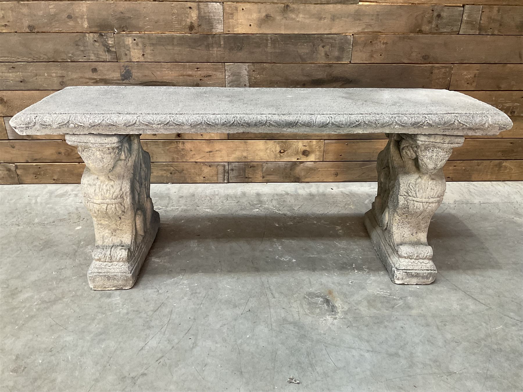 Cast stone garden Rams Head bench, two pillars set with architectural rams heads, rectangular slab seat