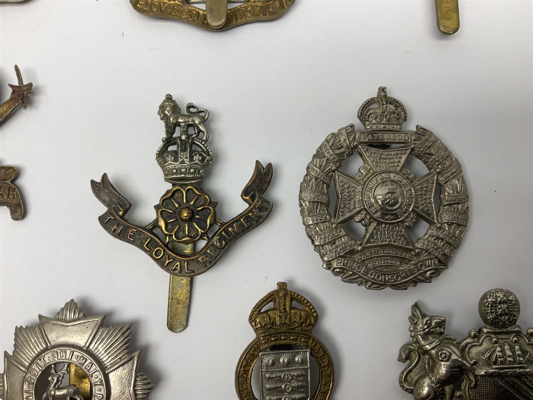 Twenty cap badges including Hertfordshire, Royal Sussex, Cambridgeshire, Hampshire, Notts and Derby, East Surrey, Herefordshire, South Lancashire, Devonshire, Bedfordshire, Durham Light Infantry etc (20)