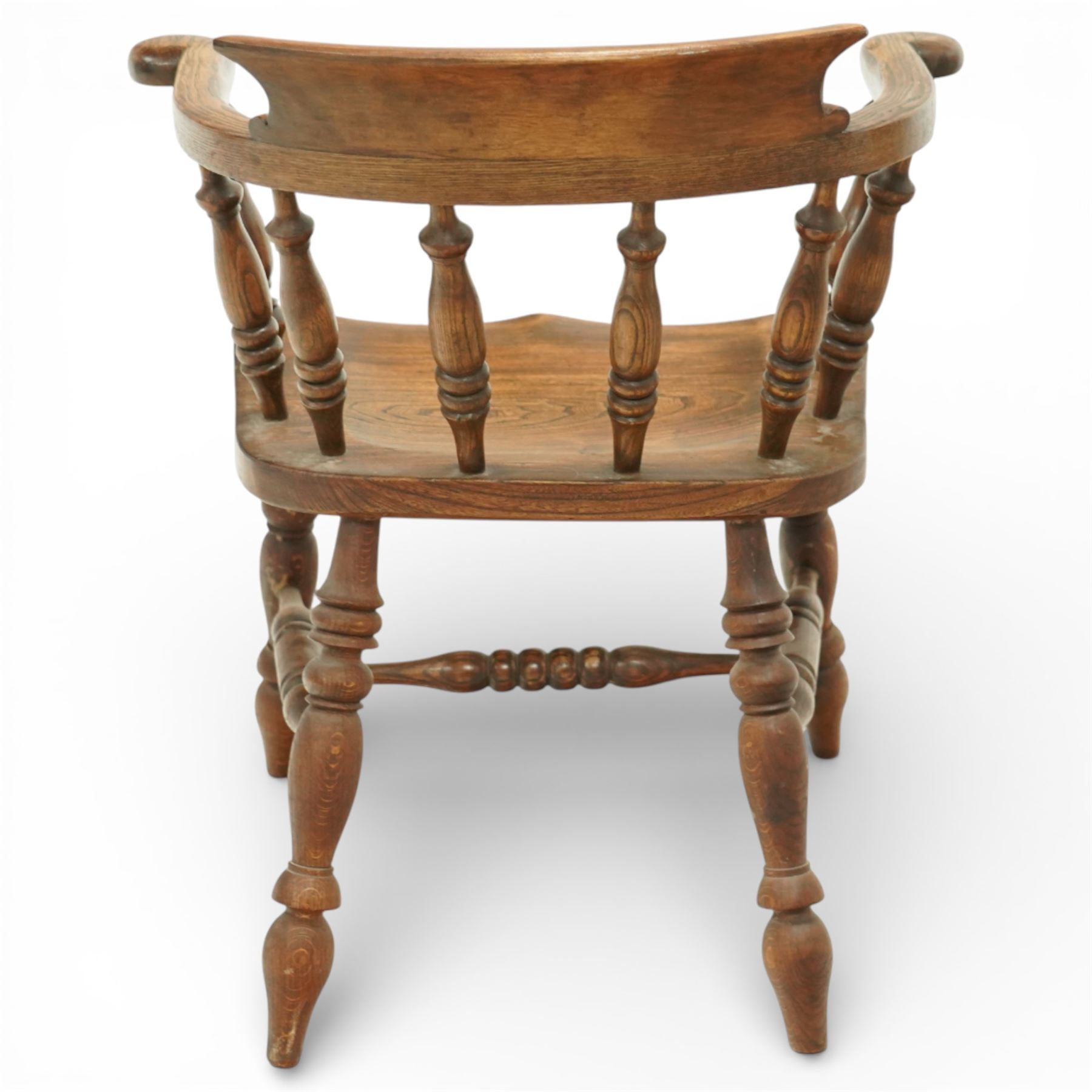 20th century captain’s oak smoker’s chair, with curved horseshoe back rail, turned spindle supports, shaped solid seat, turned legs united by stretchers