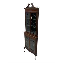 Edwardian mahogany corner display cabinet, scrolled swan neck pediment over astragal glazed doors, fabric lined interior, on cabriole feet 