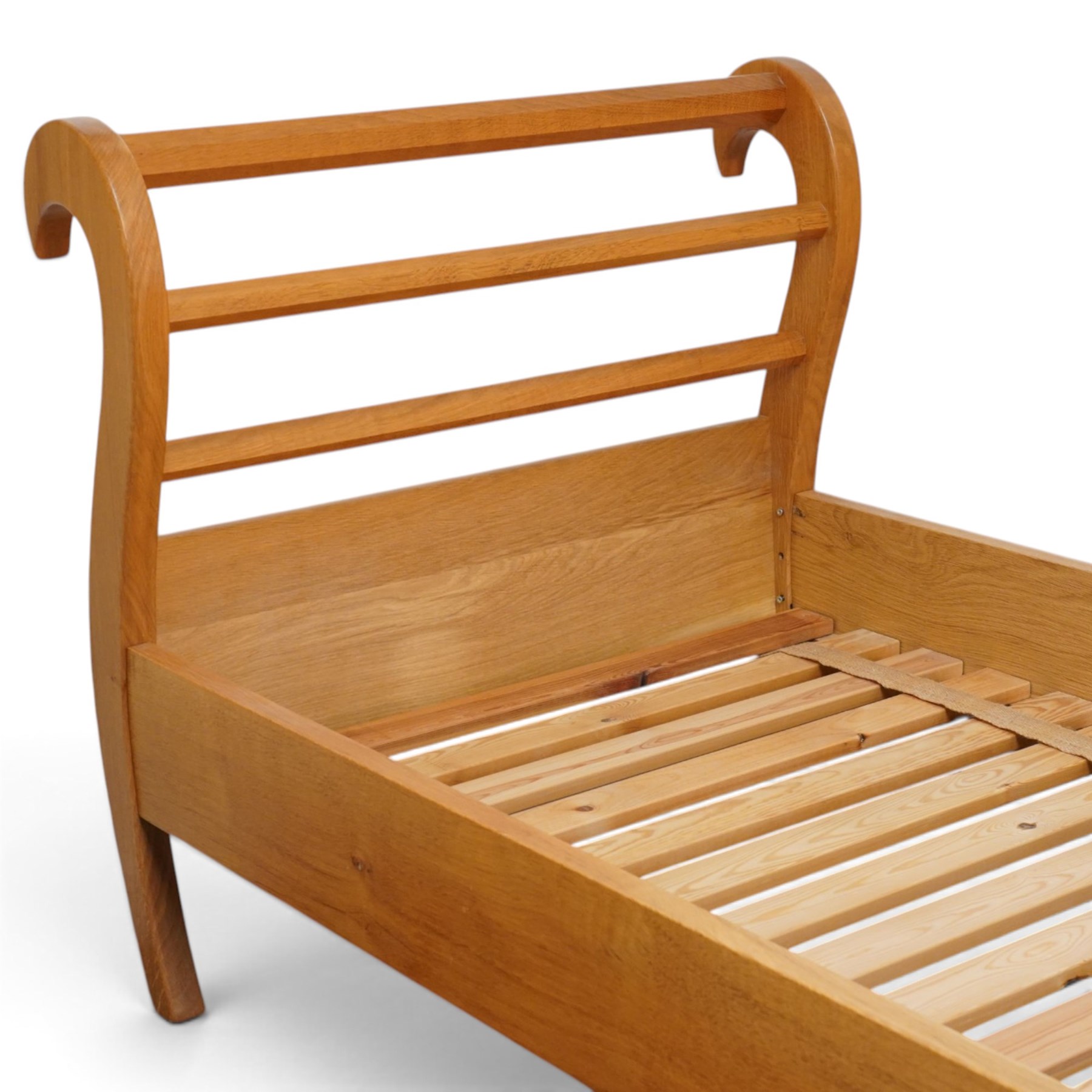 Unicornman - pair of craftsman-made oak single beds, of sleigh shape with scrolled head and foot-boards with octagonal stretchers, slatted base, raised on inward-splayed squared supports, applied with carved unicorn signature, by Geoff Gell of Coxwold