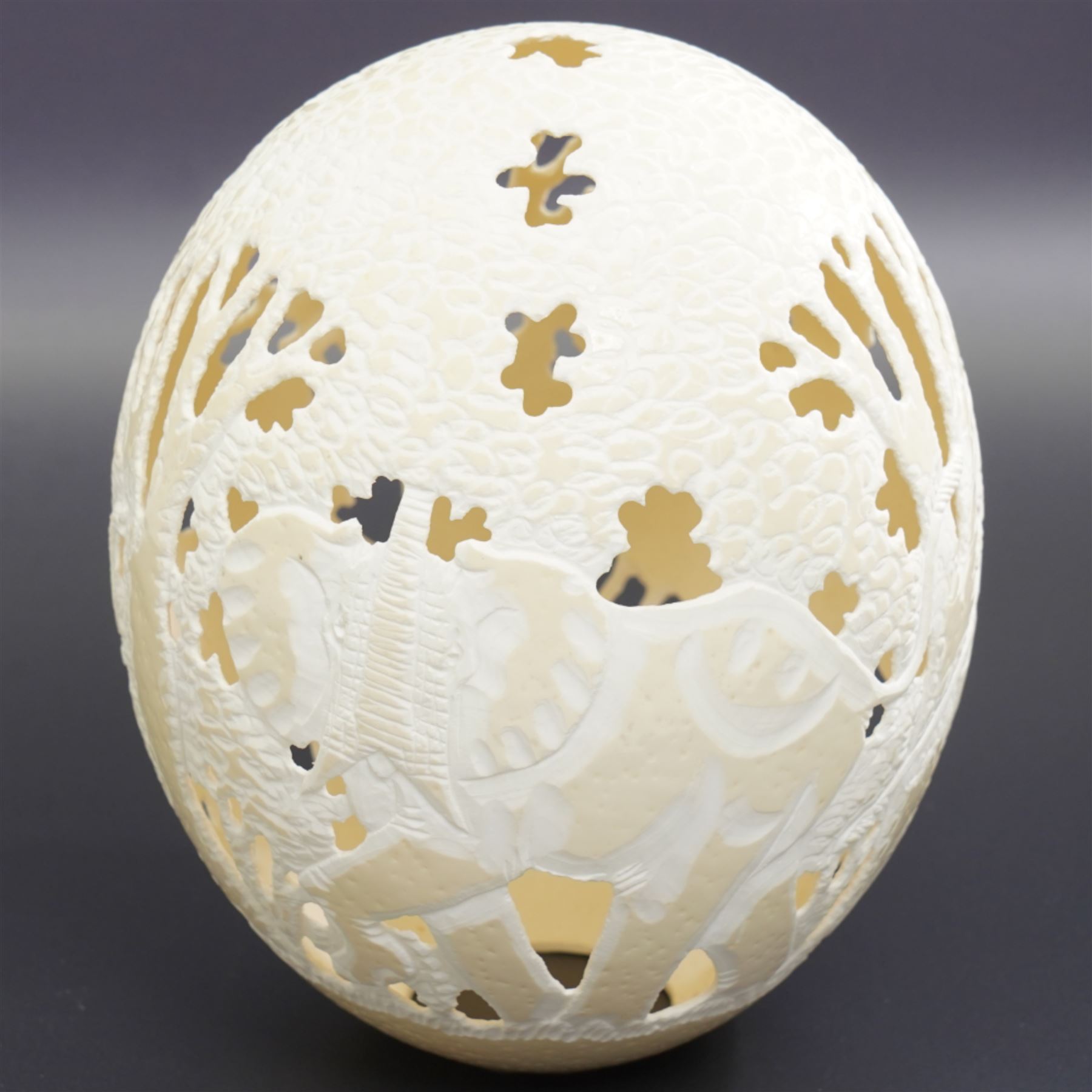 Ostrich egg with pierced decoration, depicting elephants in a forest, H16cm