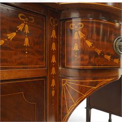 Edwardian Sheraton Revival inlaid plum pudding mahogany serpentine sideboard, rectangular top with raised gallery above bowed frieze drawer finely inlaid with central neoclassical urn motif, flanked by two drawers with swags and ribbon bows, above a cellarette drawer and cupboard, on square tapered supports with spade feet 