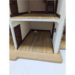 1:24 scale stone effect three-storey cottage dolls house, with green arched door and lattice effect windows, decorated to the interior with wooden floors, wired lighting and fire places, H45cm, W57cm, D26cm