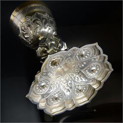 20th Century silver plated Gothic chalice, embossed throughout with fleurs de lis, foliate and bead decoration, on a knopped stem with flared and cusped foot, inset with three amethyst and two blue paste stones and applied paste and split pearl brooch, engraved beneath 'In Memory of my Mother R.I.P ... Aug 15th 1937, H23cm