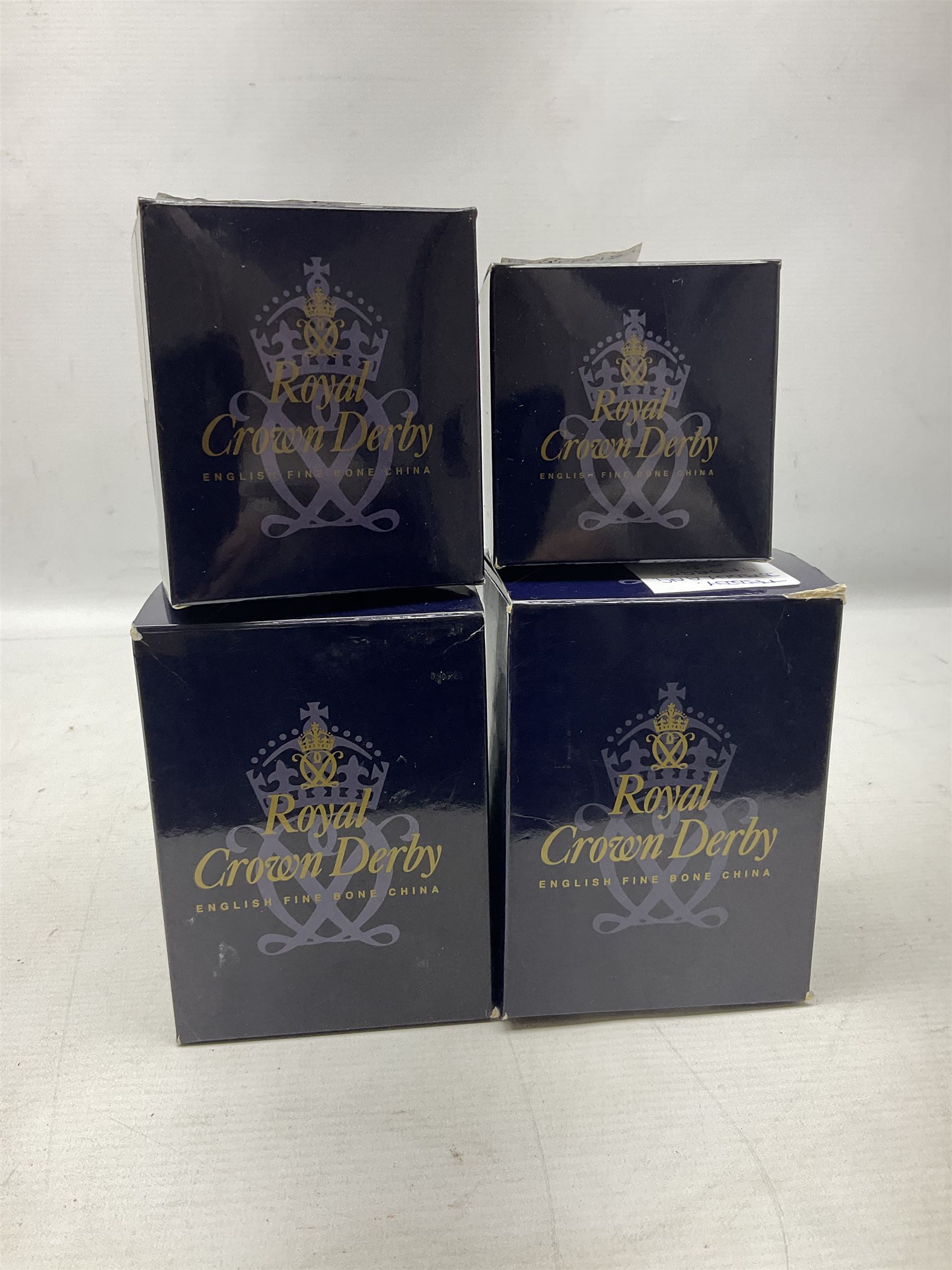 Four Royal Crown Derby teddy paperweights, comprising Teddy Cook, two Teddy George and Seated Teddy, all without stoppers, together with Crown Namestake with gold stopper 