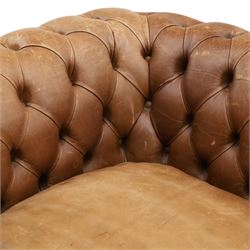 Fleming & Howland Ltd - large traditional shape four seater chesterfield club sofa, the rolled ack and arms with studwork, upholstered in buttoned tan leather with loose seat cushions, raised on large turned feet