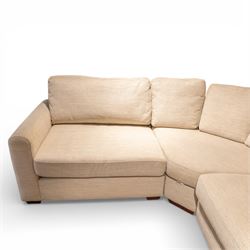 Contemporary modular corner sofa, upholstered in neutral fabric, with curved back fitted with loose cushions and wide seat pads, padded scroll arms and block feet, designed as three detachable sections
