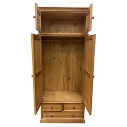 Solid pine double wardrobe, fitted with top box, enclosed by panelled doors, two short and one long drawer, on plinth base 