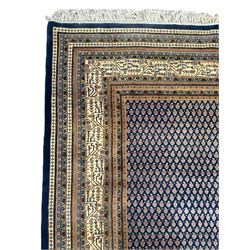 Large North-West Persian Arrak indigo ground carpet, the field decorated all-over with small Boteh motifs, multiple band border decorated with repeating geometric designs 